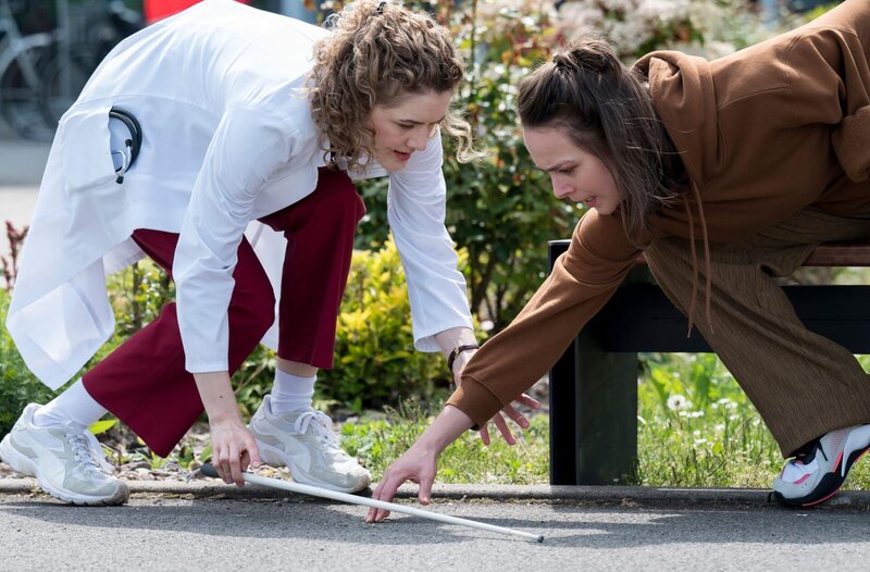 Dr. Elly Winter (Juliane Fisch, l.) hilft Melissa Recker (Marie Förster, r.), nach einem Sturz auf. – Bild: ARD/​Jens-Ulrich Koch