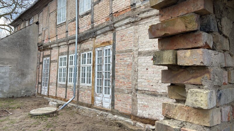 Nach drei Wochen strammer Arbeit ist die Fachwerkwand wieder hergestellt. Inklusive Feldsteinfundament. – Bild: NDR/​Populärfilm