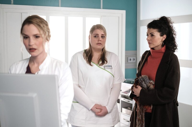 Miriam Schneider (Christina Petersen, mi. und ihre Lebensgefährtin Rieke Machold (Liza Tzschirner, re.) warten gespannt auf das Untersuchungsergebnis von Dr. Julia Berger (Mirka Pigulla, li.). – Bild: MDR/​Saxonia Media/​Robert Strehler