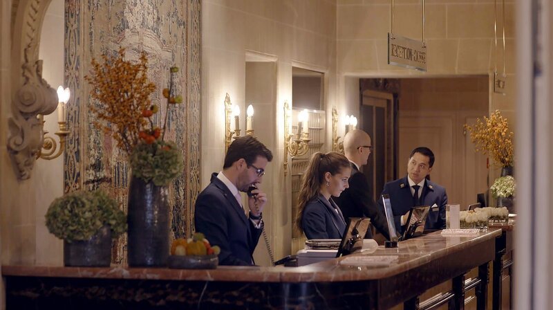 „Hotel-Legenden“ erzählt von Grandhotels als Orten mit Geschichte. Das Beau Rivage am Genfer See hat Geschichte mitgeschrieben. Unvergessen sind vor allem zwei Dramen: 1898 verstarb „Sisi“, Kaiser Elisabeth, im Beau-Rivage an den Folgen einer Messerattacke eines italienischen Anarchisten. 1987, wurde der Ministerpräsident Schleswig-Holsteins, Uwe Barschel, tot in der Badewanne gefunden. – Die Rezeption des Hotels Beau Rivage – Bild: Honorarfrei – nur für diese Sendung inkl. SocialMedia bei Nennung ZDF und rbb/​Lona Media.