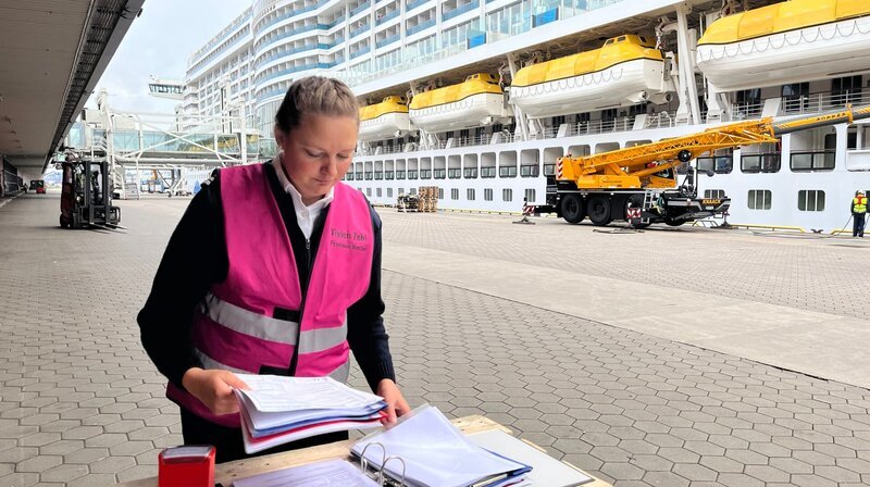 Vivien Zehl arbeitet für AIDA als Proviantmeisterin. Gerade ist sie mit dem Kreuzfahrtschiff auf der Elbinsel Steinwerder angekommen und muss neue Ladungen mit Lebensmitteln koordinieren. – Bild: NDR/​Stefan Weiße