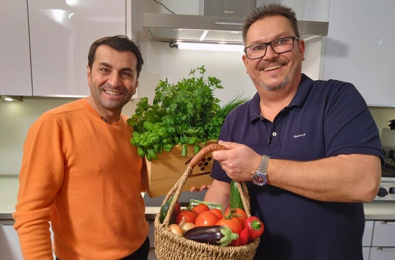 Torsten Jörn (re.), leidenschaftliche Hobbykoch aus Kassel will den Münchner Spitzenkoch Ali Güngörmüs in seinem Hauptgericht mit einem mallorquinischen „Trumbet“ überraschen, einem Gemüsegericht das er auf einer „Plancha“, einer sehr hoch erhitzbaren Metalplatte, zubereitet. – Bild: hr-fernsehen