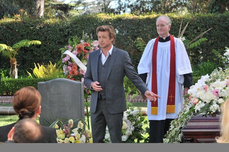 Patrick (Simon Baker, l.) muss die private Trauerfeier von Ethel Sebring unterbrechen, um einen Fall zu lösen. Der Priester (Rory Johnston, r.) ist etwas irritiert … – Bild: Warner Bros. Television