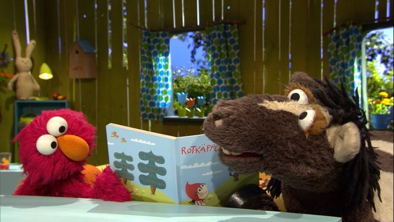 Elmo und Pferd streiten sich wegen eines Märchenbuches. – Bild: NDR/​Studio Hamburg Produktion/​Sesame workshop