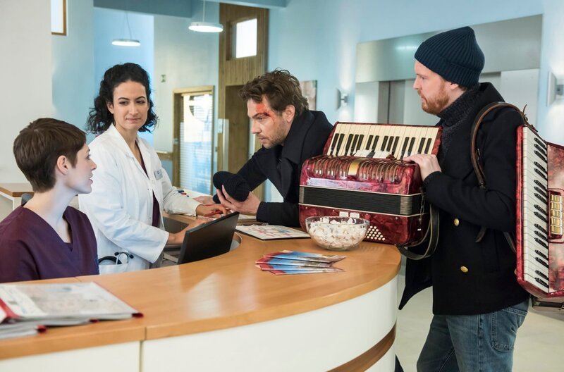 Die Musiker Matthias (Leander Lichti, 2.v.r.) und Fabian Lohe (Ole Fischer, r.) bitten Dr. Koshka (Katharina Nesytowa, l.) und Dr. Sherbaz (Sanam Afrashteh, 2.v.l.) um Hilfe. – Bild: ARD/​Jens Ulrich Koch