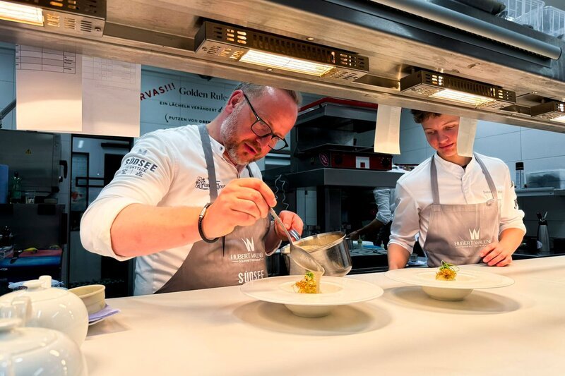 Huber Wallner mit seinem Sohn beim Finalisieren der Speisen in seiner Küche im Seerestaurant Saag – Bild: ServusTV /​ Weidinger Thomas