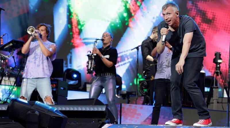 Für die Kölner Band KASALLA geht 2022 ein lang gehegter Traum in Erfüllung. Die erfolgreichen Kölschrocker feiern ihr 10-jähriges Jubiläum mit der größten Open-Air-Show ihrer Bandgeschichte. Zeitgleich mit dem Release des neuen Albums „Rudeldiere“ rockt das Quintett am 17. Juni 2022 stundenlang vor über 40.000 Zuschauer:innen im ausverkauften Kölner Fußball Stadion. Sänger Bastian Campmann von der Band Kasalla (rechts) mit Gast der deutschen Brass und Marching Band aus Bonn Querbeat,Sänger Bastian Campmann von der Band Kasalla (rechts) mit Gast der deutschen Brass und Marching Band aus Bonn Querbeat, – Bild: WDR/Thomas Brill Für die Kölner Band KASALLA geht 2022 ein lang gehegter Traum in Erfüllung. Die erfolgreichen Kölschrocker feiern ihr 10-jähriges Jubiläum mit der größten Open-Air-Show ihrer Bandgeschichte. Zeitgleich mit dem Release des neuen Albums „Rudeldiere“ rockt das Quintett am 17. Juni 2022 stundenlang vor über 40.000 Zuschauer:innen im ausverkauften Kölner Fußball Stadion. Sänger Bastian Campmann von der Band Kasalla (rechts) mit Gast der deutschen Brass und Marching Band aus Bonn Querbeat,Sänger Bastian Campmann von der Band Kasalla (rechts) mit Gast der deutschen Brass und Marching Band aus Bonn Querbeat, – Bild: WDR/Thomas Brill