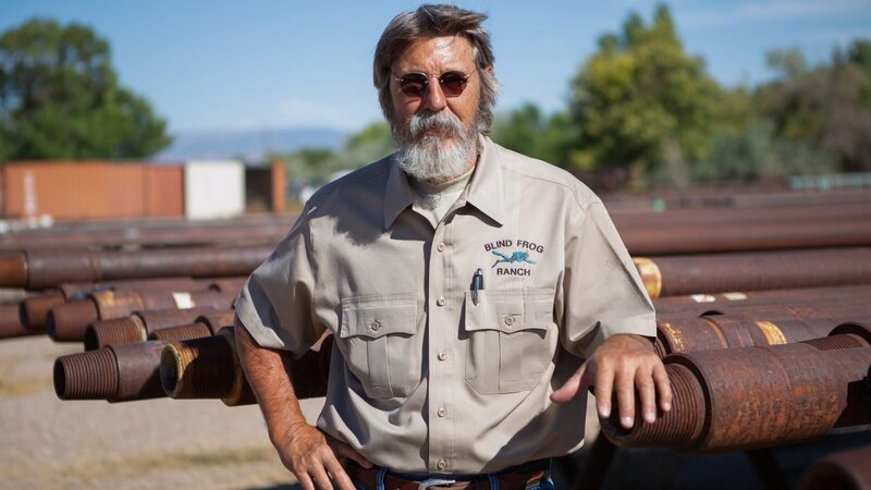 Charlie Snider leans on large metal pipes in row. – Bild: Discovery Communications, LLC