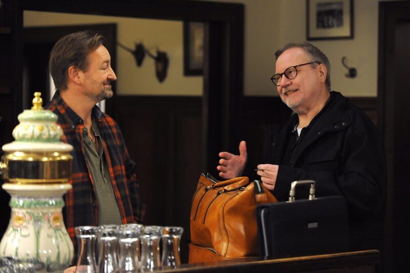 Gregor (Holger Matthias Wilhelm, links) spricht mit Fasnachtspoet Peter Kuhn im Brunnerwirt. – Bild: Marco Orlando Pichler /​ BR