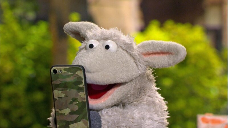 Wolle ist total begeistert von seinem neuen Handy. – Bild: NDR/​Sesame workshop