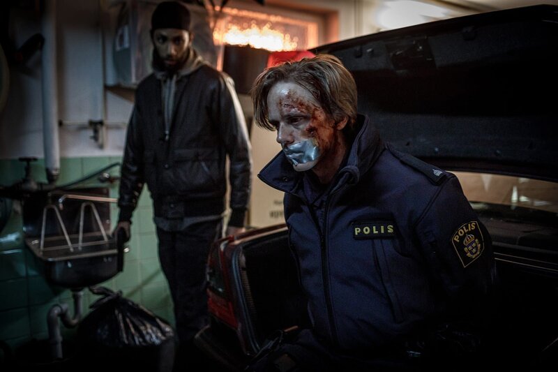 Der Polizei-Auszubildende Vilhelm Beck (Valter Skarsgård, r.) gerät in Schwierigkeiten. Milo (Lancelot Ncube, l.) und dessen Freundin Nina nehmen ihn als Geisel. – Bild: ZDF und Johan Paulin