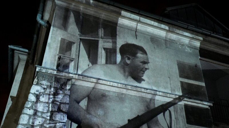  Projektion eines Fotos von SS-Massenmörder Amon Göth auf einer Hauswand. – Bild: ORF