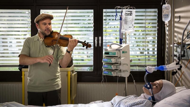 ARD MORDEN IM NORDEN Folge 51, „Ausgespielt“ (Wh.). Die 18-jährige Geigerin Paula (Caroline Hartig, r.) wurde an einem Bahnhof brutal überfallen und auf die Gleise gestoßen. Schwerverletzt liegt sie im Krankenhaus. Der Pathologe Strahl (Christoph Tomanek, l.) spielt für sie auf der Geige. – Bild: ARD/​Georges Pauly