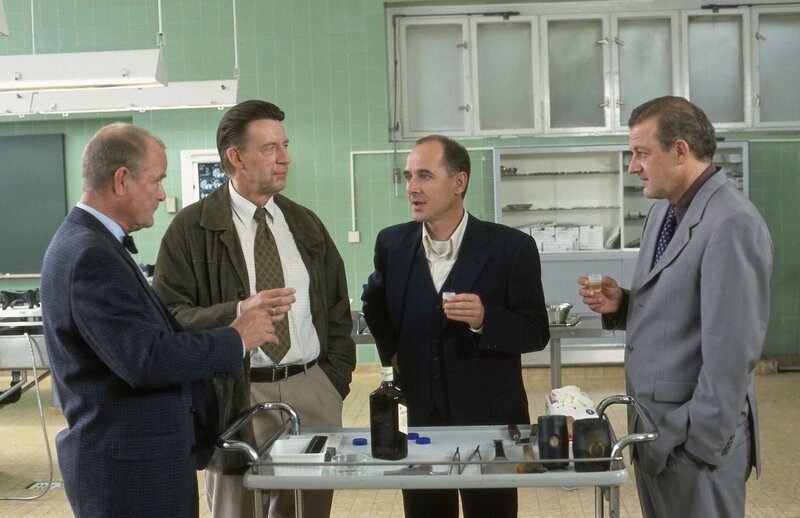 Gemeinsam feiern die Kollegen Dr. Bondzio (li.: Dieter Mann), Joe Hoffer (2. v. li.: Jörg Gudzuhm) und Dr. Kolmaar (re.: Ulrich Mühe) schon einmal den „Ausstand“ des Oberstaatsanwaltes Dr. Sänger (re.:Leonard Lansink), der nach Karlsruhe an den BGH versetzt wurde. – Bild: novafilm Berlin