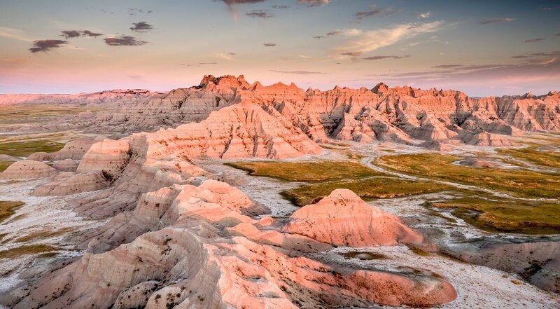Das Licht der frühen Morgensonne bringt die zerklüfteten Felsformationen der Badlands zum Leuchten. – Bild: port.hu