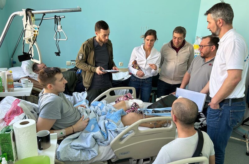 Militär-Krankenhaus in Kyiv: Janine von Wolfersdorff (Mitte) begleitet von Berliner Prothesentechnikern trifft zum ersten Mal auf den Unterschenkel-amputierten Valera Omelchenko (im Bett liegend). – Bild: WDR/​Michael Günther