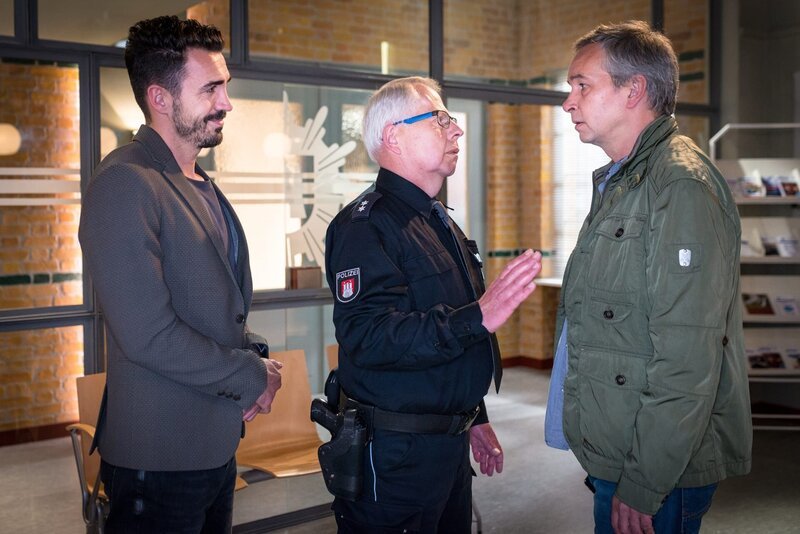 Wolle (Harald Maack, M.) hält Eugen Bossmann (Thomas Dannemann, r.) zurück, der Kostic (Blerim Destani, l.) vorwirft, für den brutalen Überfall auf seinen Sohn Viktor verantwortlich zu sein. – Bild: ZDF und Boris Laewen