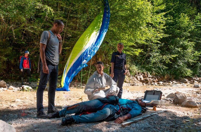Der Profi-Paraglider Mike Bischoff ist in den Tod gestürzt. War es kein Unfall? Die Ermittlungen der Kommissare bestätigen zunehmend diese These. V.l.n.r. Jerry Paulsen (Peter Marton), Pathologin Sonja Bitterling (Genoveva Mayer), Caro Reiser (Sarah Thonig) und Komparsen. – Bild: BR/​ARD/​Lucky Bird Pictures/​Angela Schablitz