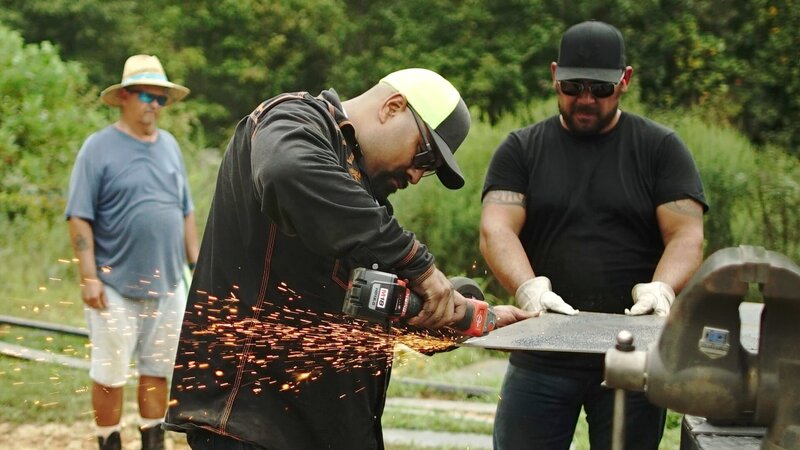 L-R: Juan Ibarra, Travis Stockman, sawing piece of metal – Bild: Warner Bros. Discovery, Inc. or its subsidiaries and affiliates.