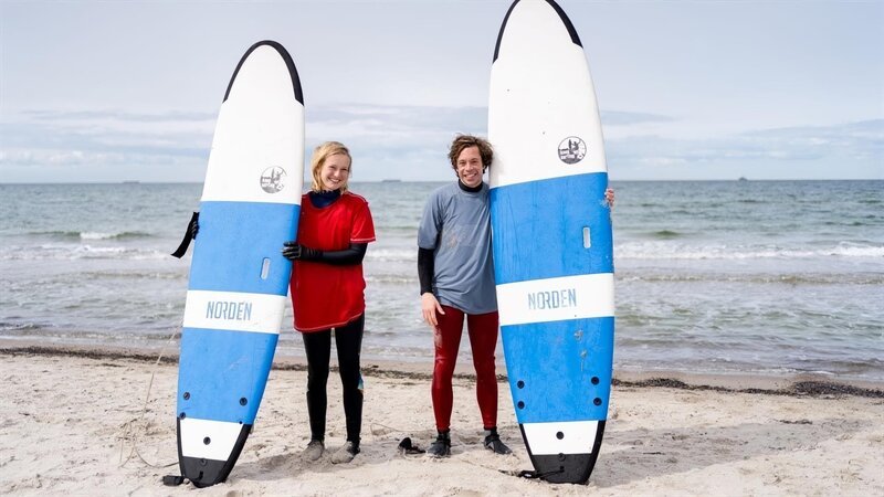 Am Meer zeigt Surflehrerin Fiona Checker Tobi, wie er eine Welle richtig reitet. – Bild: BR/​megaherz gmbh/​Hans-Florian Hopfner