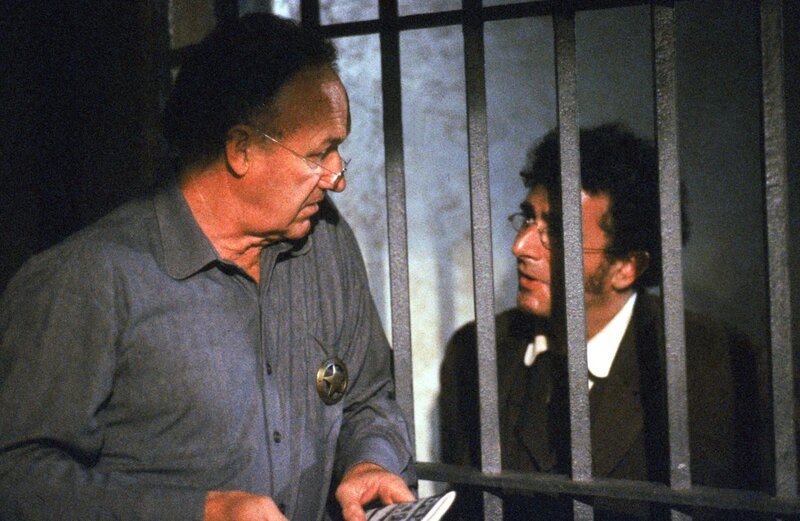 Der Journalist Beauchamp (Saul Rubinek), der zunächst die Biographie von English Bob schreiben wollte, ist mit fliegenden Fahnen zu Sheriff Bill Daggett (Gene Hackman) übergelaufen. – Bild: ServusTV Der Journalist Beauchamp (Saul Rubinek), der zunächst die Biographie von English Bob schreiben wollte, ist mit fliegenden Fahnen zu Sheriff Bill Daggett (Gene Hackman) übergelaufen. – Bild: ServusTV