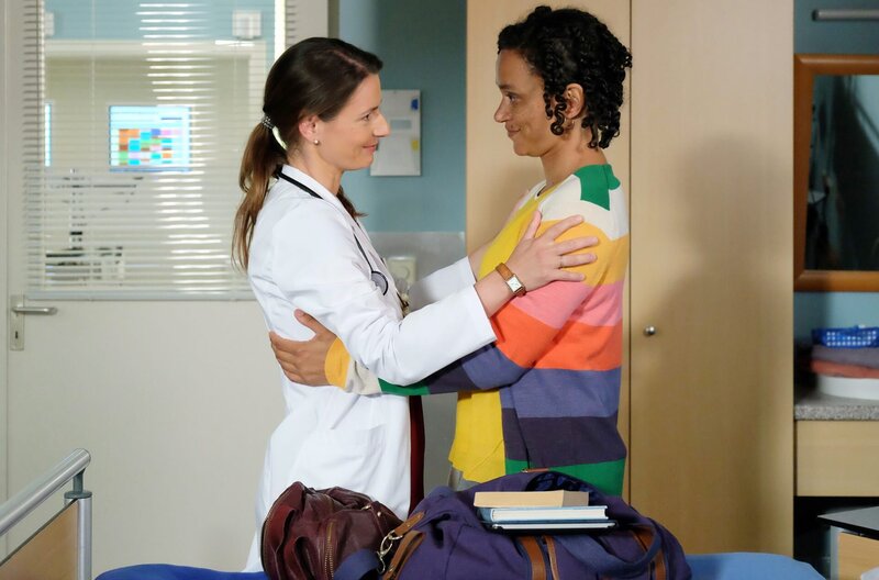 Endlich sind die beiden ehemals besten Freundinnen allein und können sich richtig begrüßen. Maria bedauert sehr, dass sie sich so lange nicht gesehen haben und entschuldigt sich bei Iris. Hätte sie gewusst, dass auch Iris sich damals auf die Stelle in München beworben hatte, hätte sie ihre Bewerbung zurückgezogen. Iris ist das sichtbar unangenehm, doch auch sie freut sich, Maria endlich wiederzusehen. – Bild: MDR/​Saxonia Media Filmproduktion/​Kiss