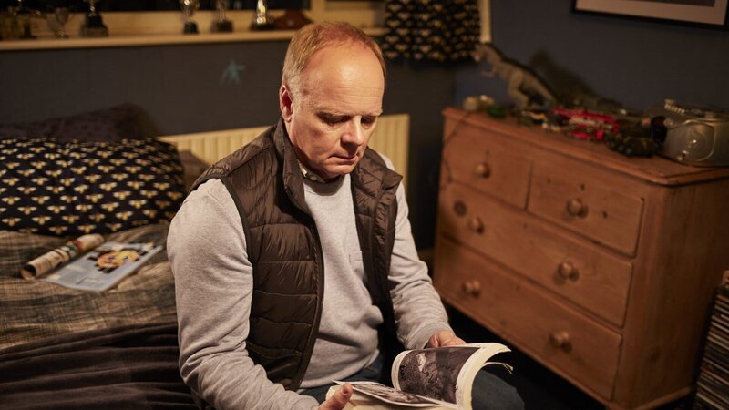 Simone Duke (Jason Watkins) findet in Liams Tasche ein Buch über die Krähe. Was hat das bloß zu bedeuten? – Bild: ZDF und Justin Slee