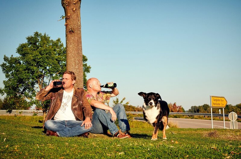 Prost: Franz (Sebastian Bezzel) und Rudi (Simon Schwarz) genießen ihr Feierabend-Bier. – Bild: ARD Degeto/​BR/​Constantin Film/​Bernd Schuller