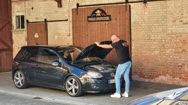 Eine Person überprüft ein Auto. – Bild: Warner Bros. Discovery, Inc. or its subsidiaries and affiliates