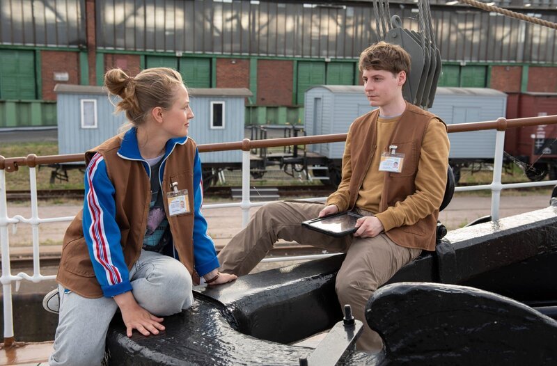 Timo (Filip Januchowski, r.) ist heimlich in Neele (Helena Sattler, l.) verliebt, die ein Volontariat auf dem Museumsschiff macht. – Bild: ARD/​Thorsten Jander