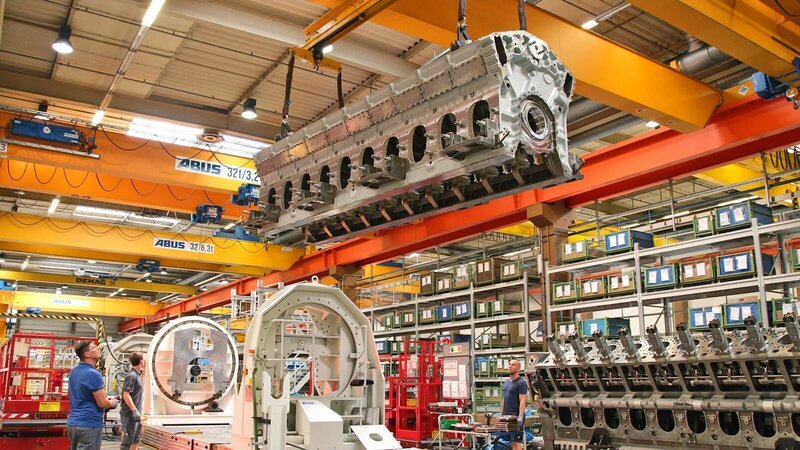 Bildunterschrift: In mehreren Schritten wird die eiserne Grundplatte des Motors mit den Kolben, der Kurbelwelle und den Pumpen verschraubt. – Bild: N24 Doku Bildunterschrift: In mehreren Schritten wird die eiserne Grundplatte des Motors mit den Kolben, der Kurbelwelle und den Pumpen verschraubt. – Bild: N24 Doku