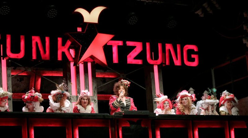 Der WDR zeigt daher „Die lustigsten Karnevalsnummern der Stunksitzung“ aus den letzten Jahren: Klassiker wie „Scheiße verkleidet“, „De Böösch“ oder die „Schlechte Laune Sitzung“ dürfen da nicht fehlen. – Sitzungspräsidentin und Moderatorin Biggi Wanninger mit dem Elferrat – Bild: WDR/​Thomas Brill