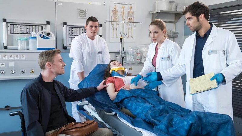 SENDER: ARD – SENDETITEL: In aller Freundschaft – Die jungen Ärzte Folge 151 – UNTERTITEL: Zweite Chancen – CAPTION: ARD IN ALLER FREUNDSCHAFT – DIE JUNGEN ÄRZTE FOLGE 151, „Zweite Chancen“, am Donnerstag (16.08.18) um 18:50 Uhr im ERSTEN..Laura Decker (Tabea Bettin, liegend) wird die in der Notaufnahme eingeliefert. Sie hat sich bei einem Sturz aus ihrem Rollstuhl verletzt. Zusammen versorgen Niklas (Roy Peter Link, r.) und Julia (Mirka Pigulla, 2.v.r.) die junge Frau. Laura wird von ihrem Freund Daniel (Eric Bouwer, l.) begleitet, der ebenfalls im Rollstuhl sitzt..© ARD/​Jens-Ulrich Koch, honorarfrei – Verwendung gemäß der AGB im engen inhaltlichen, redaktionellen Zusammenhang mit genannter ARD-Sendung bei Nennung „Bild: ARD/​Jens-Ulrich Koch“ (S2+). ARD-Programmdirektion/​Bildredaktion, Tel: 089/​5900–23534, Fax: 089/​550–1259, bildredaktion@DasErste.de – Bild: ARD/​Jens-Ulrich Koch