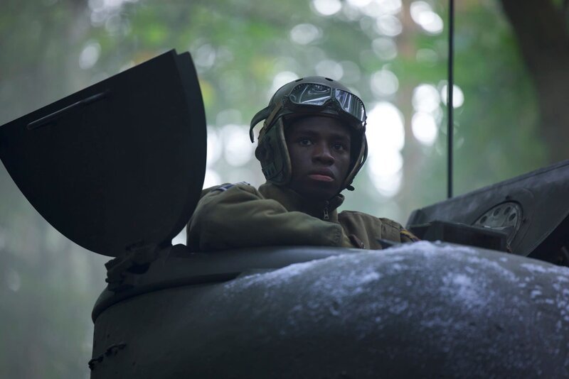 Der Panzerkommandant des 761st Black Panther Tank Battalion, Johnnie Stevens (gespielt von Juwon Adedokun), ist in einem Panzer in einer historischen Nachstellung der Ardennenschlacht zu sehen, die für „Erased: WW2’s Heroes of Color“. Staff Sergeant Johnnie Stevens war ein Panzerkommandant des 761st Black Panther Tank Battalion, der im Zweiten Weltkrieg diente. – Bild: Rekha Garton