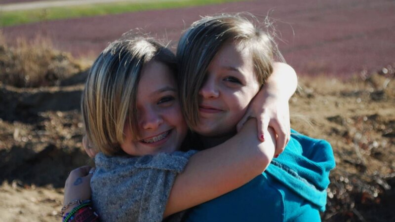Lächelnde Kinder, die sich gegenseitig umarmen. – Bild: Crime + Investigation /​ A+E Networks