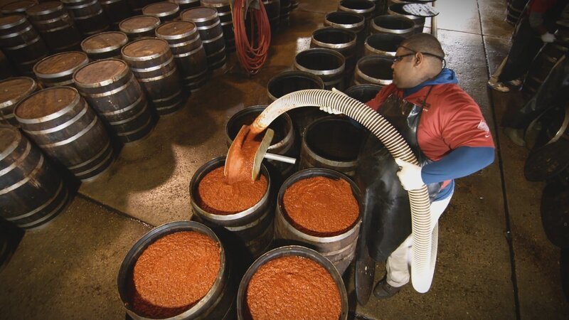 Worker using pipe to fill barrels with mash. (National Geographic/​Alex Macdonald) – Bild: The National Geographic Channel.