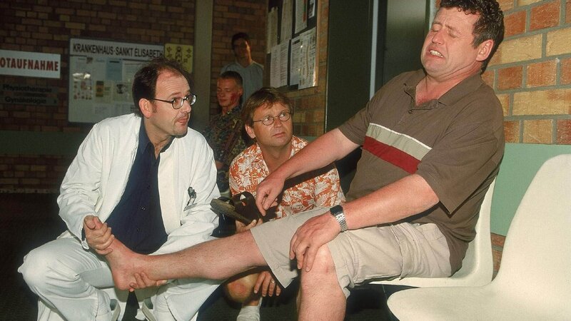 Benno (Willi Thomczyk, re.) hat sich von Lothar (Rene Heinersdorff, Mi.) ins Krankenhaus fahren lassen. Doch der Arzt (Michael Quast) bescheinigt Benno dummerweise nur eine leichte Verstauchung … – Bild: TVNOW /​ Frank Dicks