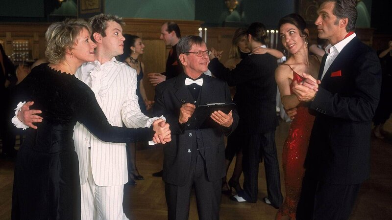 Tanzlehrer Ockerblom (Herbert Feuerstein, Mi.) hat viel Spaß an seinen ambitionierten Tanzschülern (li.: Mariele Millowitsch, Oliver Reinhard, re. Komparsin, Walter Sittler). – Bild: Foto: TVNOW /​ Guido Engels