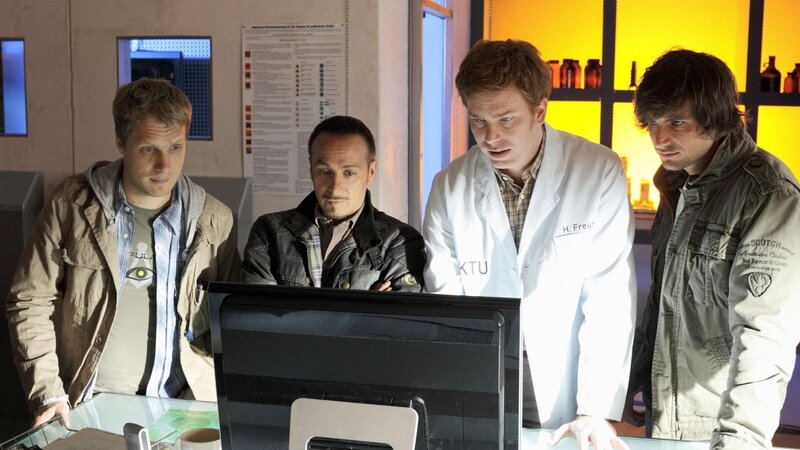 Hartmut (Niels Kurvin, 2.v.r.) präsentiert Sturmi (Oliver Pocher, l.), Semir (Erdogan Atalay, 2.v.l.) und Ben (Tom Beck) die Daten aus dem zerstörten Rechner: den Bauplan eines neuartigen und extrem gefährlichen Grippevirus. – Bild: RTL /​ Guido Engels