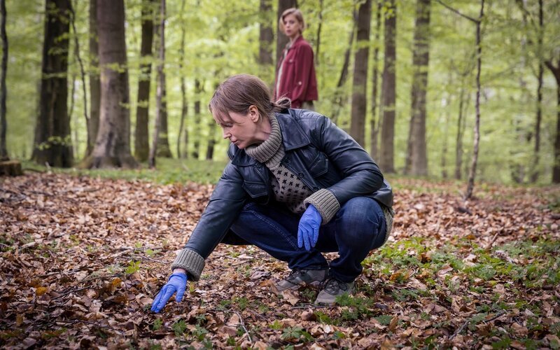 Iris (Sofia Helin, vorne) ist zunächst überrascht darüber, dass ihre Kollegen gelegentlich mit dem Medium Isabell (Matilda Dahl, hinten) zusammenarbeiten. – Bild: ZDF und Carolina Romare