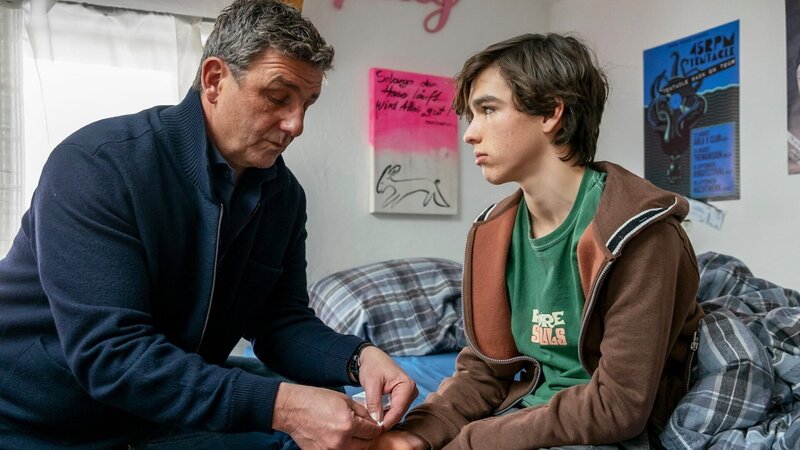 Mann verarztet Junge, der auf einem Bett sitzt, v.li.: Hans Sigl als Bergdoktor Dr. Martin Gruber, Matteo Miska als Fabian Bichler – Bild: SRF/​ZDF/​Erika Hauri