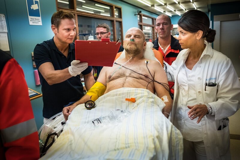 Haase (Fabian Harloff, l.) übergibt Gerd Reimann (Alexander Radszun, M.) an Jasmin (Gerit Kling, r.). Der Tischlermeister hat in seiner Werkstatt einen Herzinfarkt erlitten, konnte aber noch einen Notruf absetzen. – Bild: ZDF und Boris Laewen
