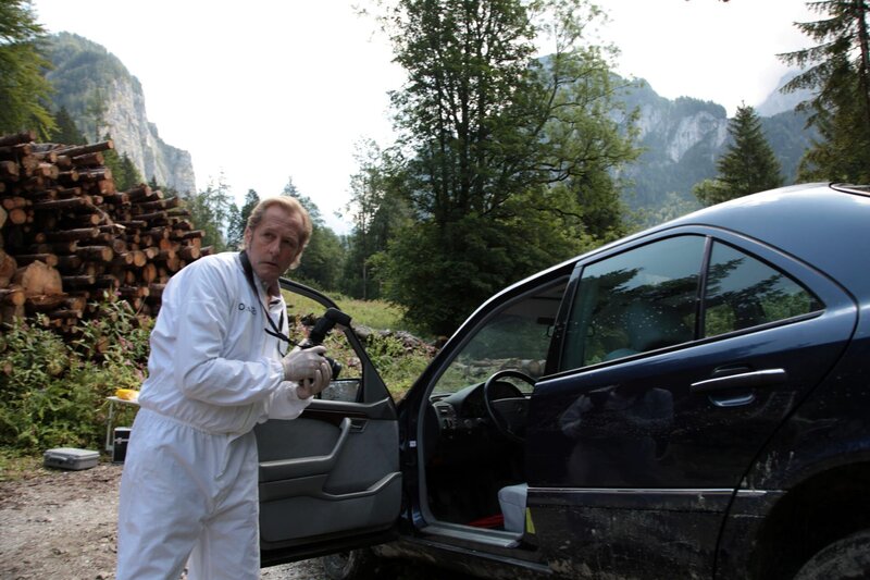 Wohlfahrt macht Fotos vom Tatort, es gibt zwei Tote, einer davon am Beifahrersitz des Autos. (Spurensicherer Franz Wohlfahrt). – Bild: Bavaria Media GmbH