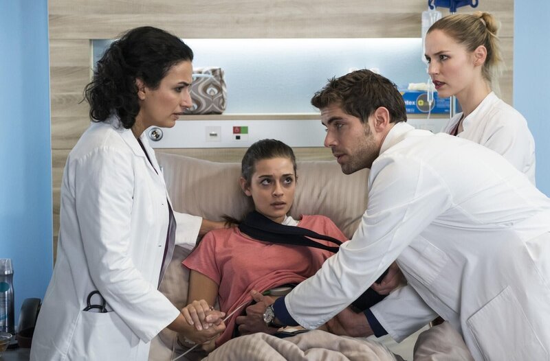 Nach der Schulter-OP spürt Zoe (Melina Fabian, M.) einen Druck im Bauch. Niklas (Roy Peter Link, r. mit Mirka Pigula, r.) und Dr. Leyla Sherbaz (Sanam Afrashteh, l.) machen sich Sorgen um das Baby. – Bild: ARD Degeto
