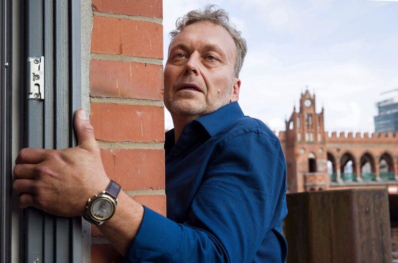 Manfred Kerner (Thomas Schmuckert), Inhaber des K&K-Kurierdienstes, ringt auf dem Fenstersims seines Büros an der Oberbaumbrücke um sein Leben. – Bild: ARD/​Daniela Incoronato