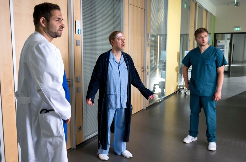 Dr. Matteo Moreau (Mike Adler, l.) und Mikko Rantala (Luan Gummich, r.) bekommen es mit einem sehr besonderen Patienten zu tun. Sascha Miesner (David Baalcke, M.) wird nach einem Sturz eingeliefert und denkt, er sei im Himmel. – Bild: ARD/​Jens-Ulrich Koch
