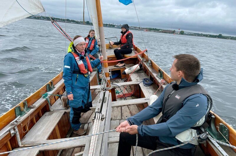 Kiel in Deutschland. Ausflug: Segeln mit den Passagieren Robert Falk und Rebecca Dörner und den Segeltrainerinnen Laura Schwilp und Daria Bohl. – Bild: BR/​Bewegte Zeiten Filmproduktion GmbH/​Gerrit Mannes