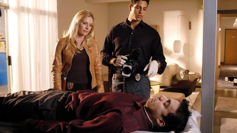 Dr. Carlos Garza (Randy Lewis Hernandez, vorne), Anästhesist an einer Beauty-Klinik, wird erhängt in seinem Appartement aufgefunden. Selbstmord oder Mord? Calleigh (Emily Procter) und Delko (Adam Rodriguez) suchen nach Spuren. – Bild: TVNOW /​ CBS