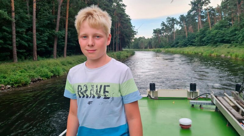 Der 11-Jähige Friedrich (Foto) gehört zu einer Binnenschiffer-Familie. Er mag es auf dem Wasser zu sein, denn dann fühlt er sich frei. Friedrich hat wichtige Aufgaben an Bord. Er kann zum Beispiel das Schiff am Tau an- und ablegen, putzt auf und unter Deck oder kocht auch schon mal das Mittagessen. Er ist überall dabei und hilft, wo er gebraucht wird. – Bild: rbb/​Preuss Filmproduktion Berlin