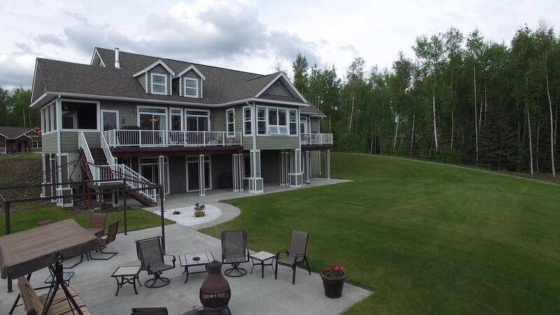 View of the backyard and exterior of the Wasilla Golf House, one of the stops in Luke and Kassandra Higgins’ Alaska house search, as seen on Great American Country’s Living Alaska – Bild: Great American Country/​Scripps Networks, LLC.